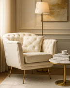 Sillón de tela y metal color crema con cojín.